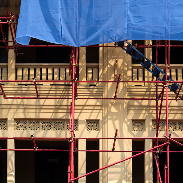 A blue tarp covering a building with scaffolding.